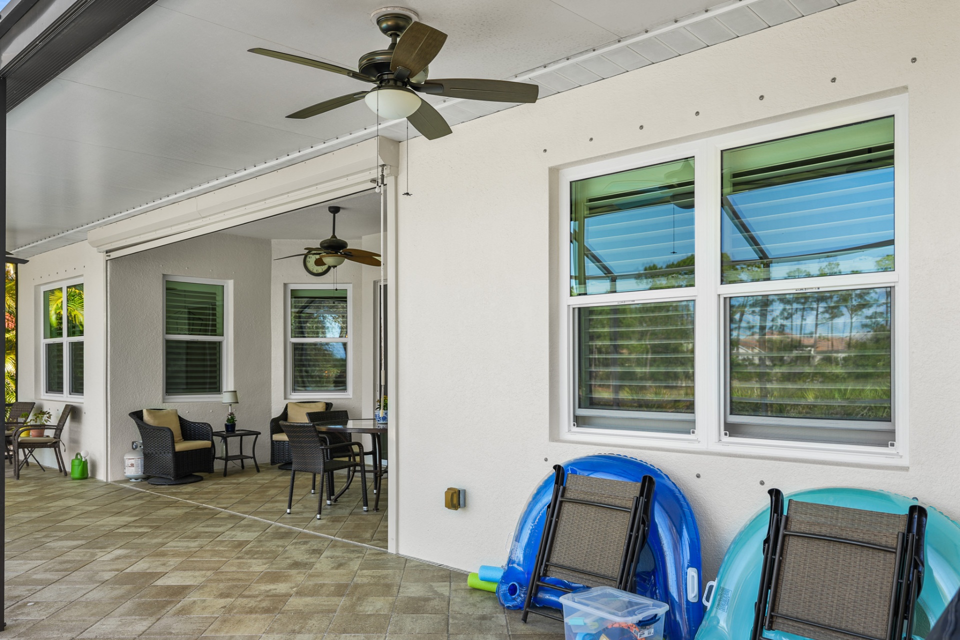Covered patio with multiple new impact windows overlooking yard