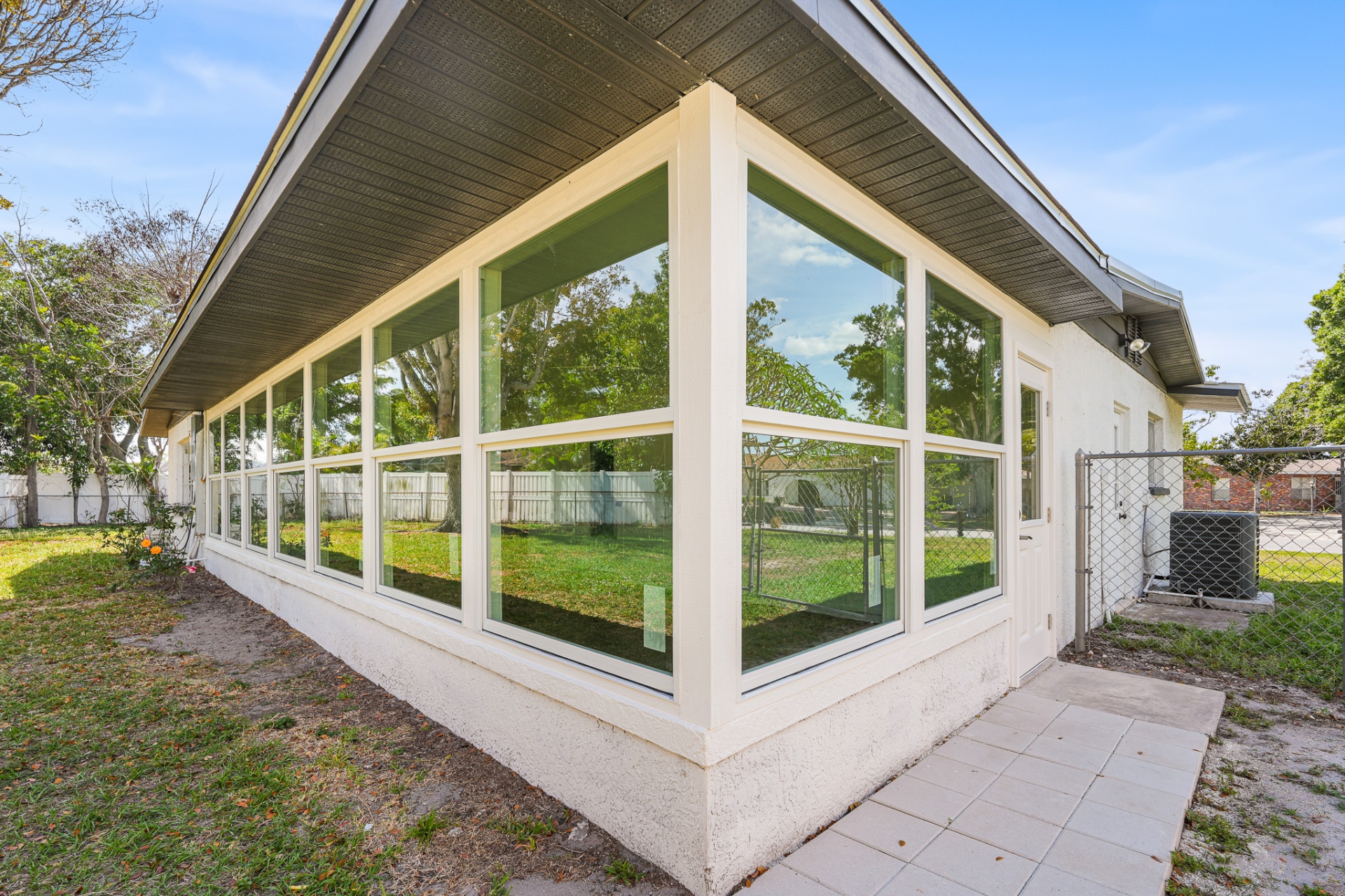 Corner view of Florida room enclosure with floor-to-ceiling impact glass