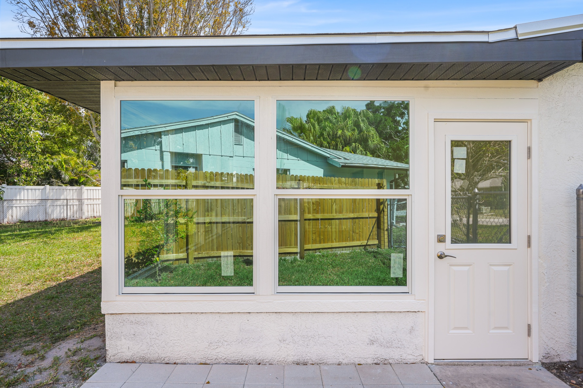 Sunroom impact windows flanking a new exterior door