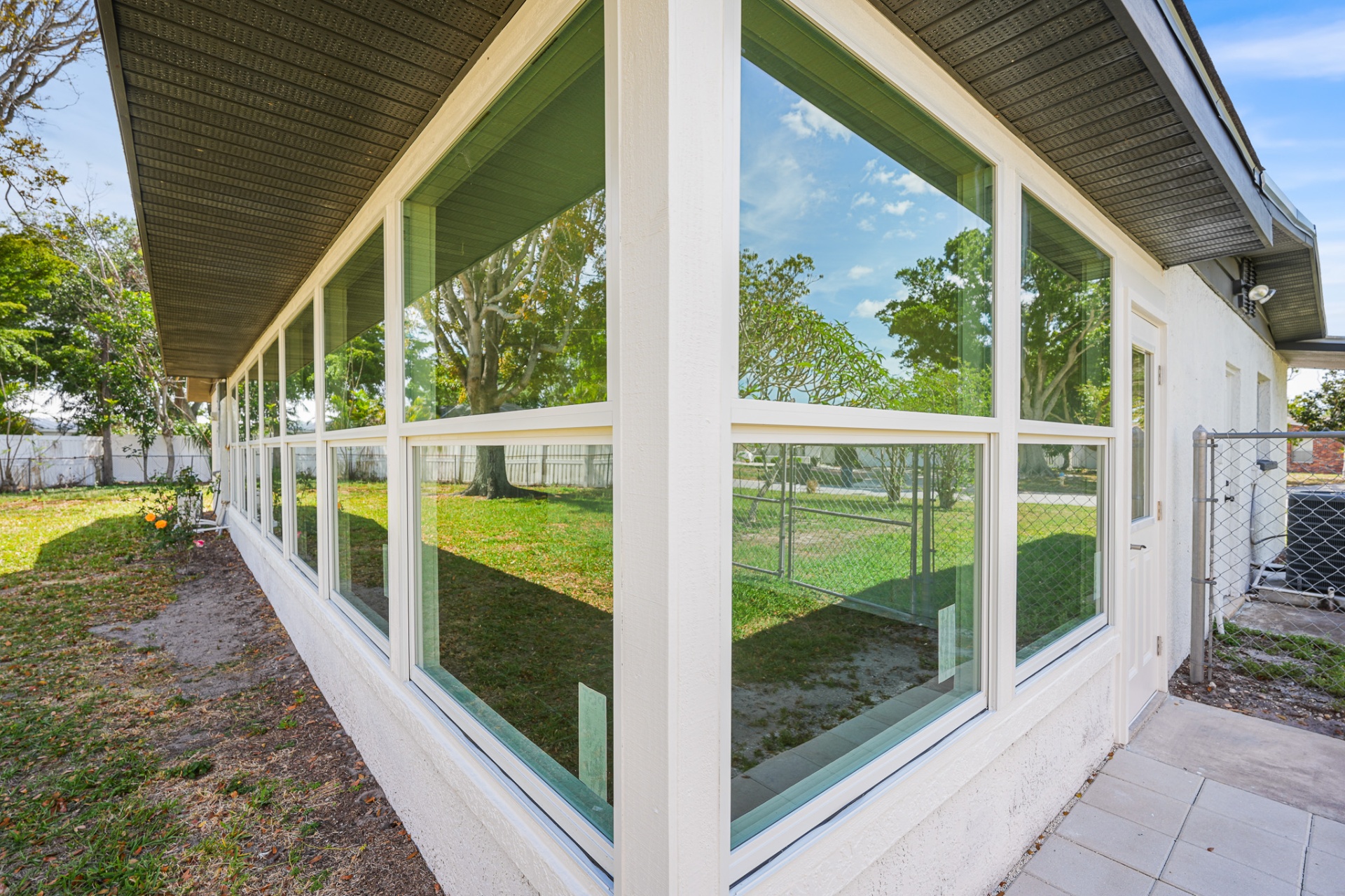 Sunroom enclosure showcasing wraparound impact windows