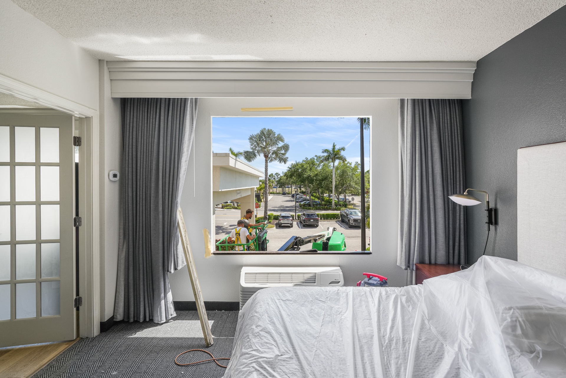 Hotel guest room with new impact picture window overlooking palms and parking